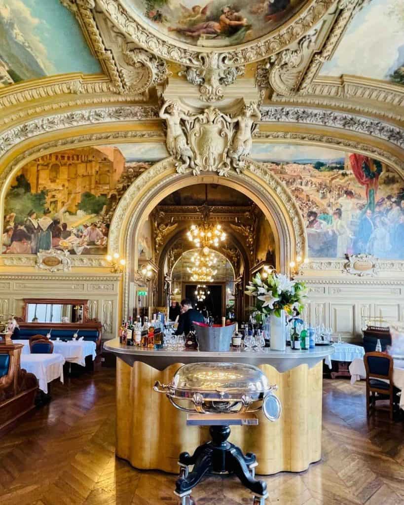 A stunning beaux arts interior of a Paris restaurant including frescoed ceilings