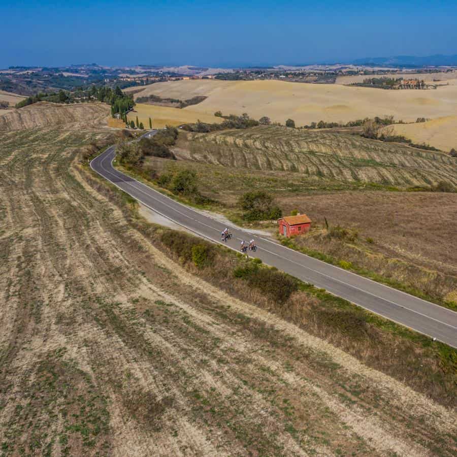 Cyclists ride through the open landscape and fields of Sicily.